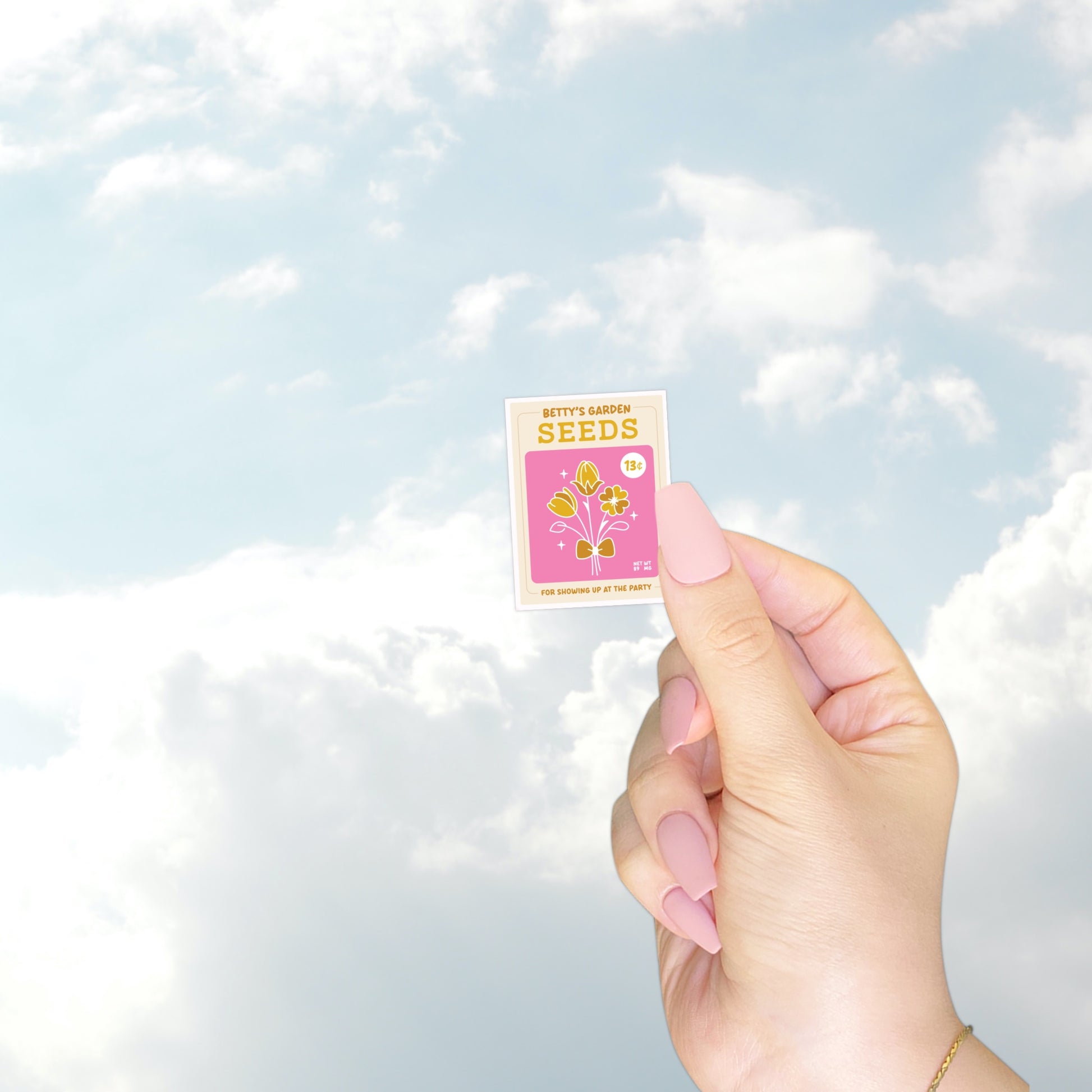 A pink vintage-style seed packet labeled “Betty’s Garden Seeds.” It shows golden flowers with a bow and reads “for showing up at the party.”