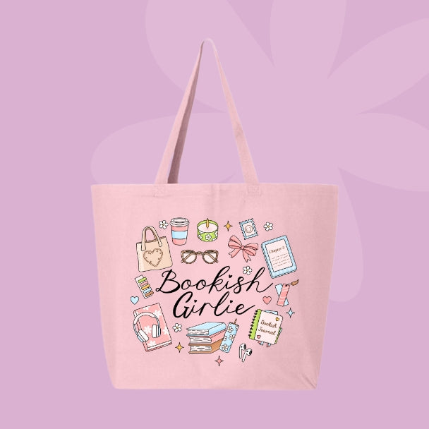 Pink tote bag with doodles of cozy items like books, coffee, candles, bows, glasses, and text that says “Bookish Girlie.”