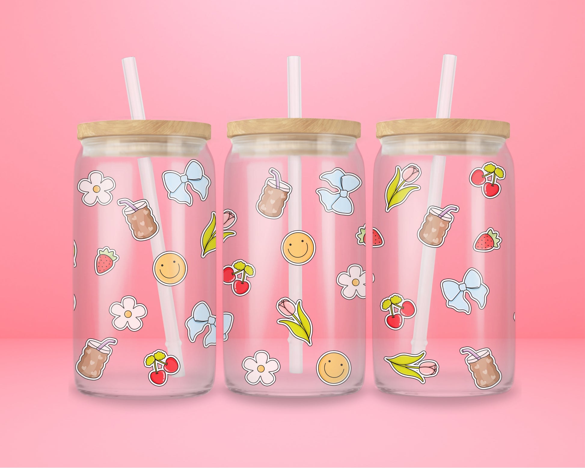 Glass cup with iced coffee cups, cherries, blue bows, tulips, strawberries, smiley faces, and white flowers scattered on a pink background.