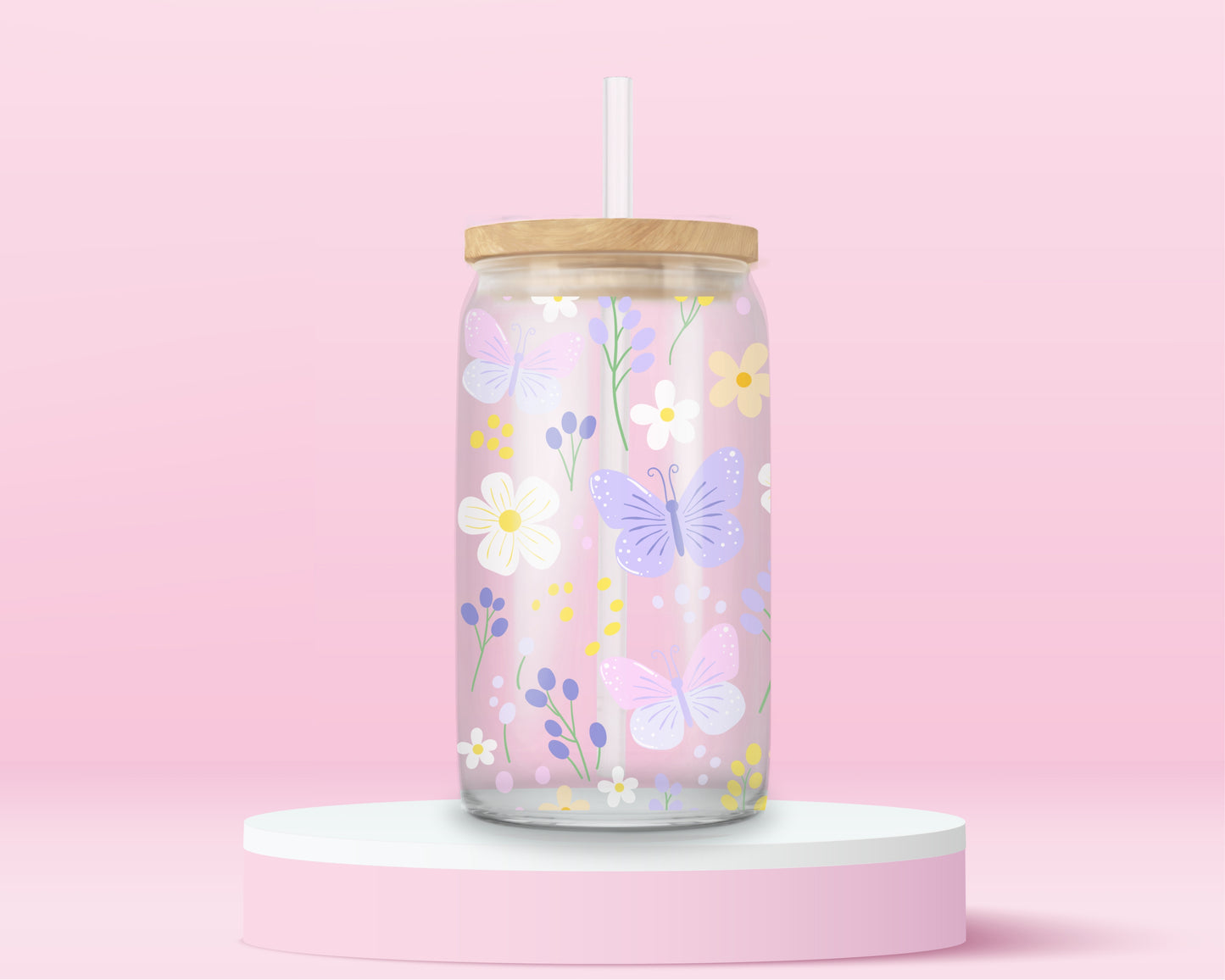 A pink glass cup decorated with pastel butterflies, daisies, and wildflowers in soft yellow, lilac, and white. A dreamy spring garden in glass form.