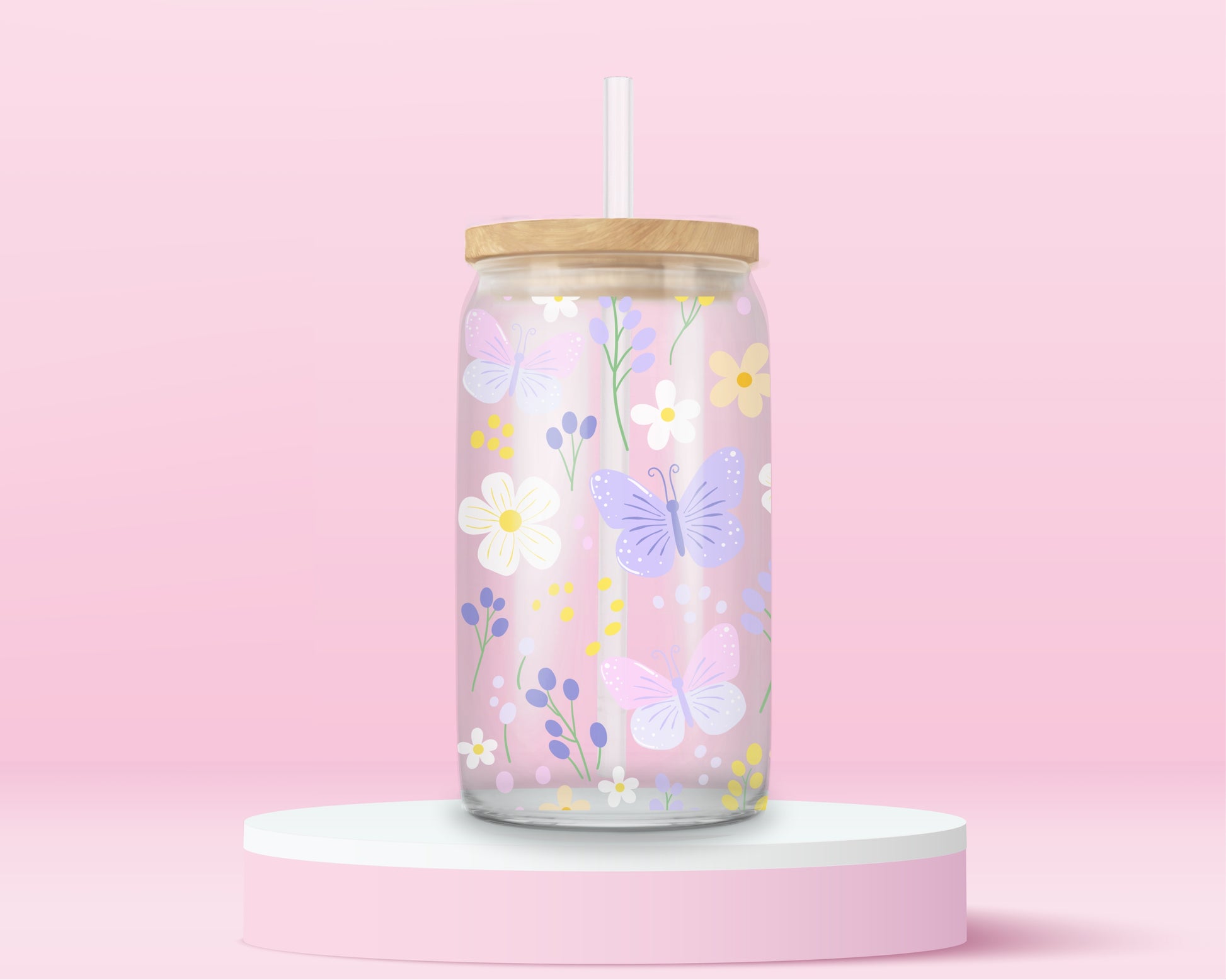 A pink glass cup decorated with pastel butterflies, daisies, and wildflowers in soft yellow, lilac, and white. A dreamy spring garden in glass form.