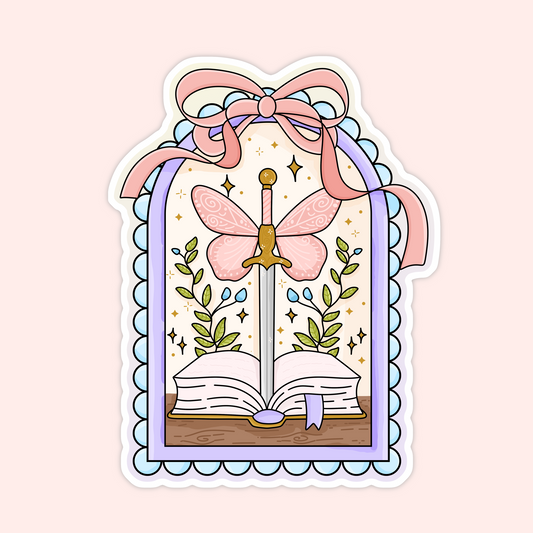 Sticker of a sword with butterfly wings rising from an open book, framed with pink bows and greenery.