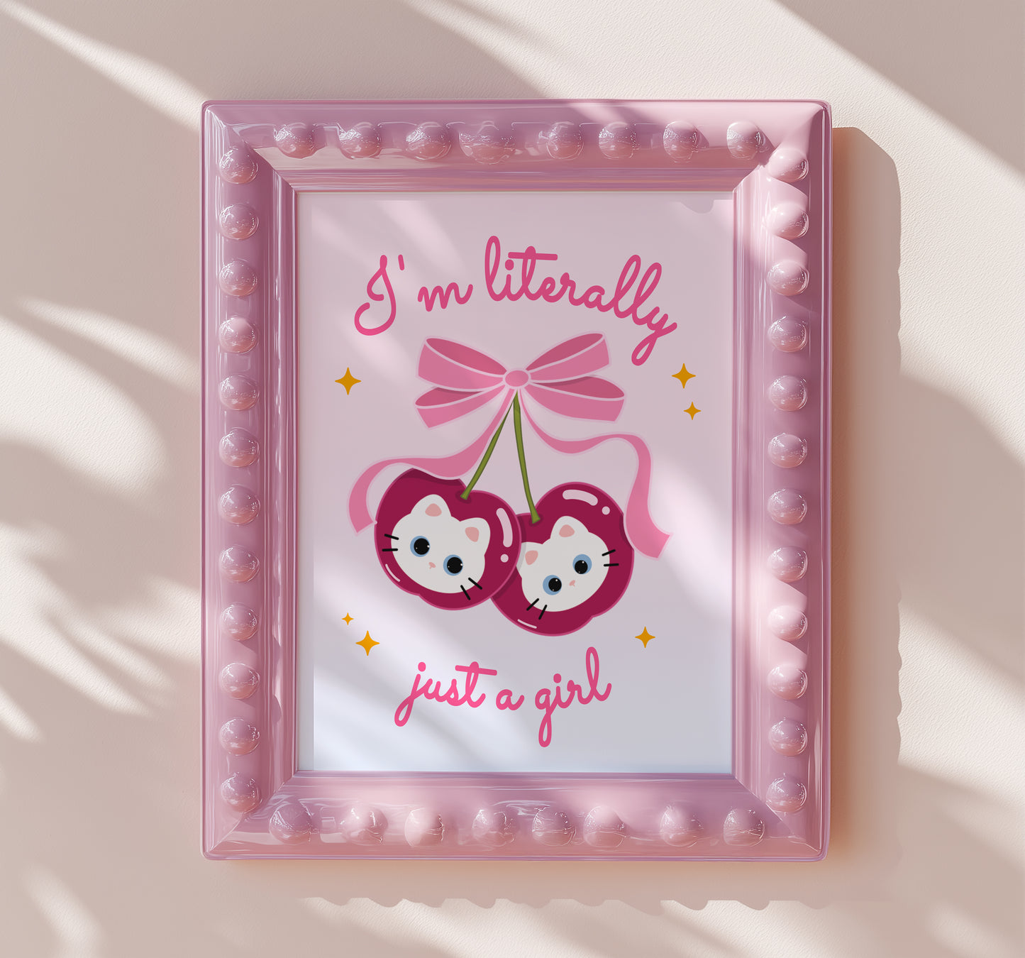 Pair of shiny red cherries with white kitten faces and a big pink bow, with the phrase “I’m literally just a girl.”