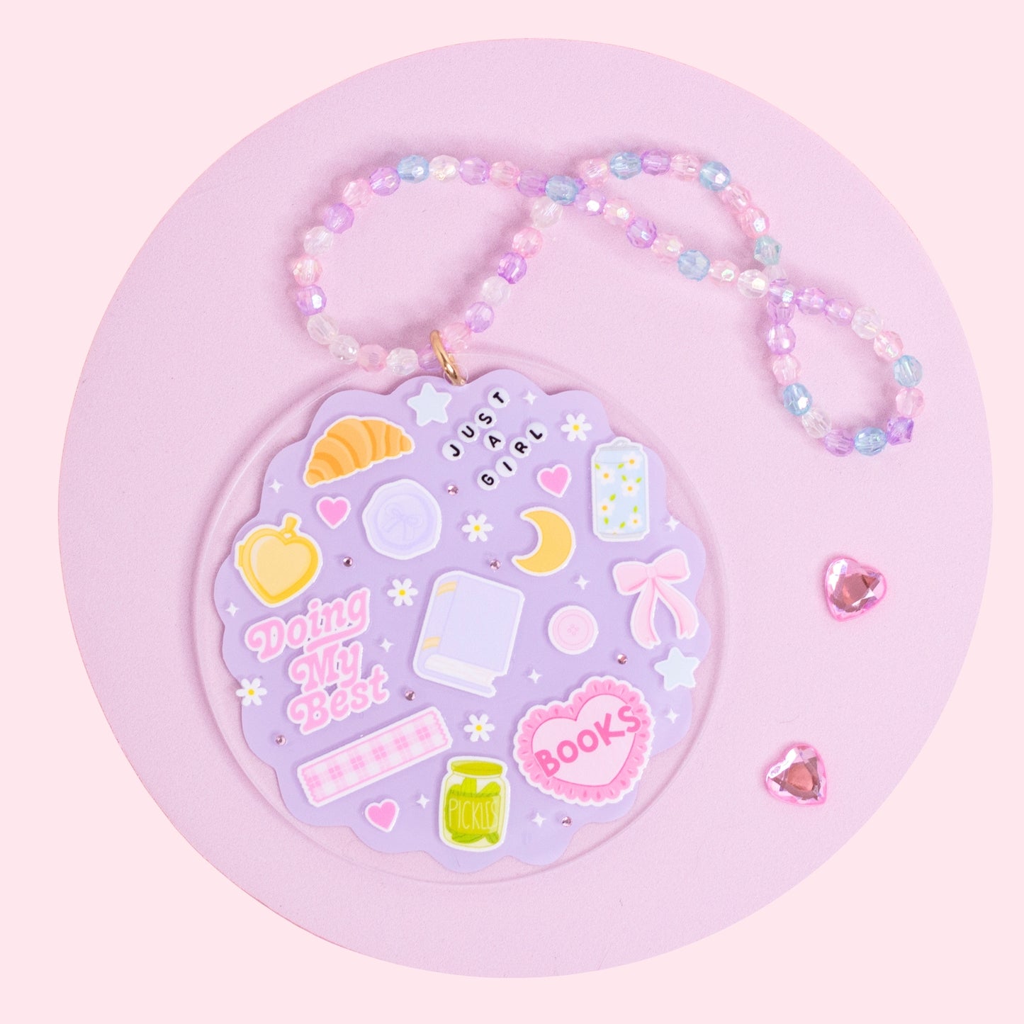lavender aesthetic acrylic car charm with books, croissant, bows, stars, and pastel beaded hanger