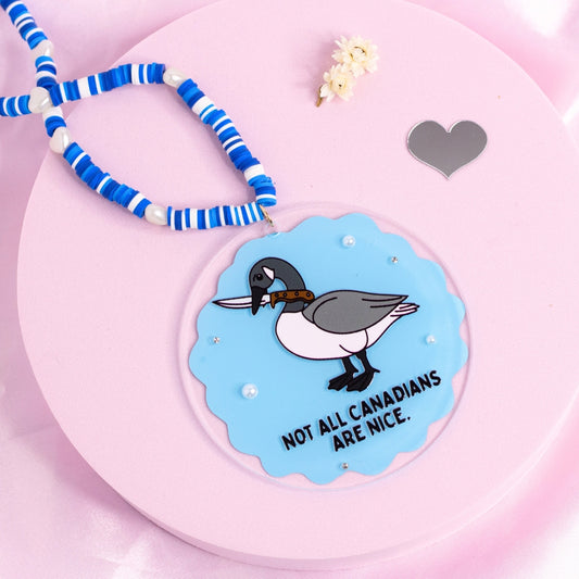 โFunny goose car charm with โNot all Canadians are niceโ quote โ bold acrylic accessory with blue beaded hanger.โ