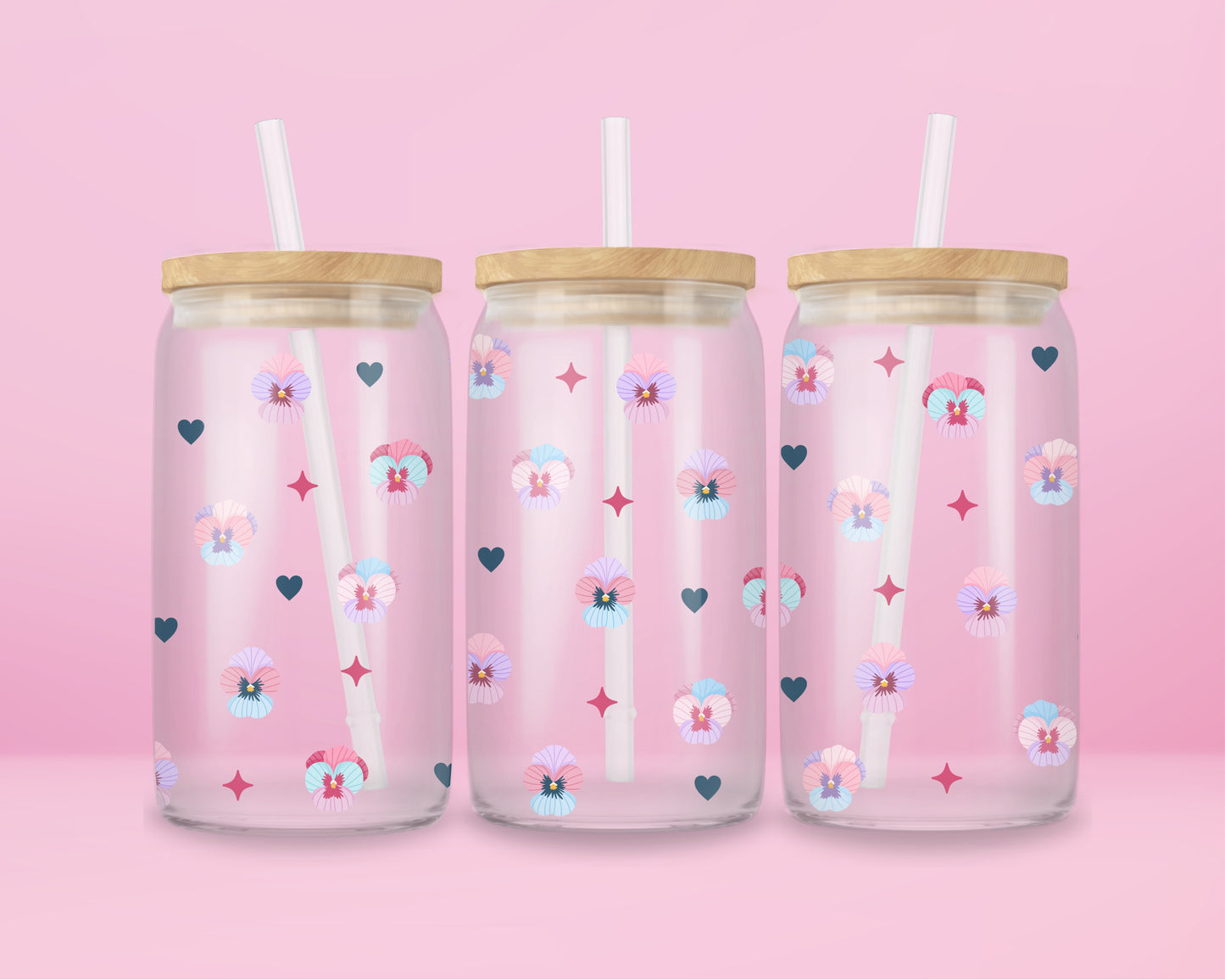 Glass cup with pastel pansies, navy blue hearts, and star sparkles on a soft pink background.