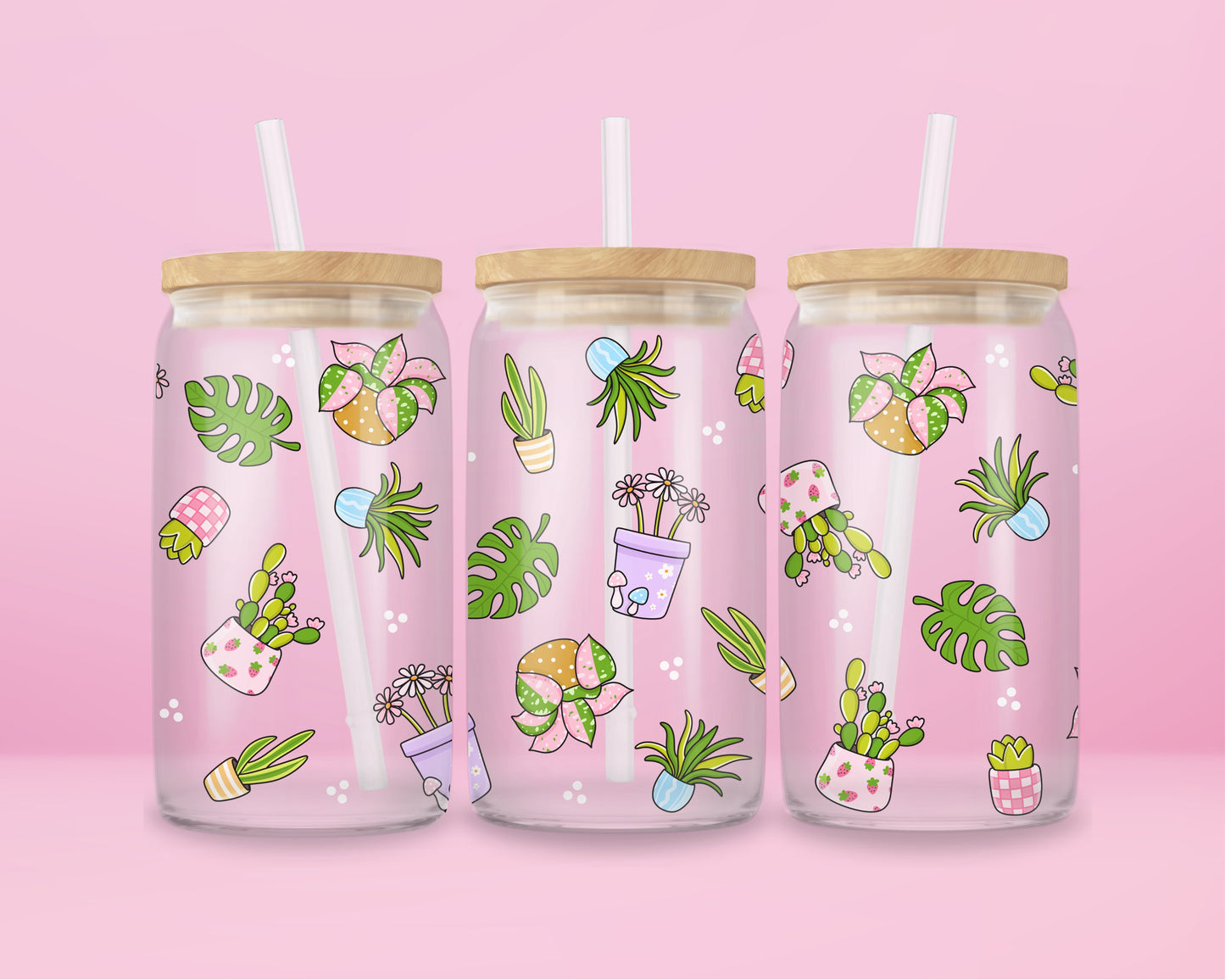 Glass can tumbler with bamboo lid and glass straw featuring potted plants, leafy greens, daisies, cacti, and botanical illustrations on a pink background.