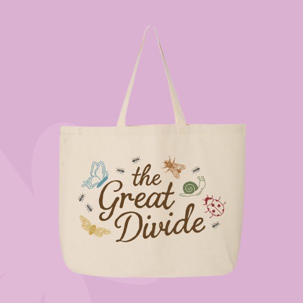 Large beige canvas tote bag featuring the words The Great Divide with illustrated butterflies, bees, snails, ladybugs, ants, and nature-inspired bug details.
