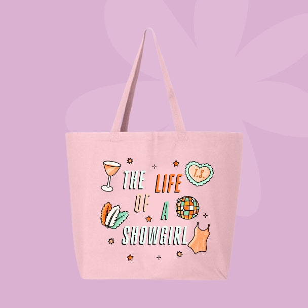 Pink tote bag with colorful doodles like a disco ball, cocktail, corset, and heart with “T.S.” text that says “The Life of a Showgirl.”