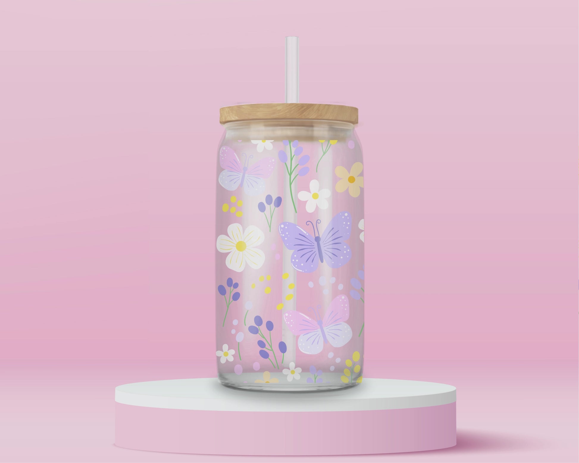 A pink glass cup decorated with pastel butterflies, daisies, and wildflowers in soft yellow, lilac, and white. A dreamy spring garden in glass form.