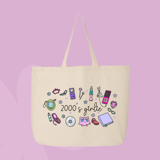 Large beige canvas tote bag featuring the words 2000’s girlie surrounded by Y2K icons including a flip phone, lip gloss, CD, butterfly clip, sneakers, mp3 player, and cute doodles.