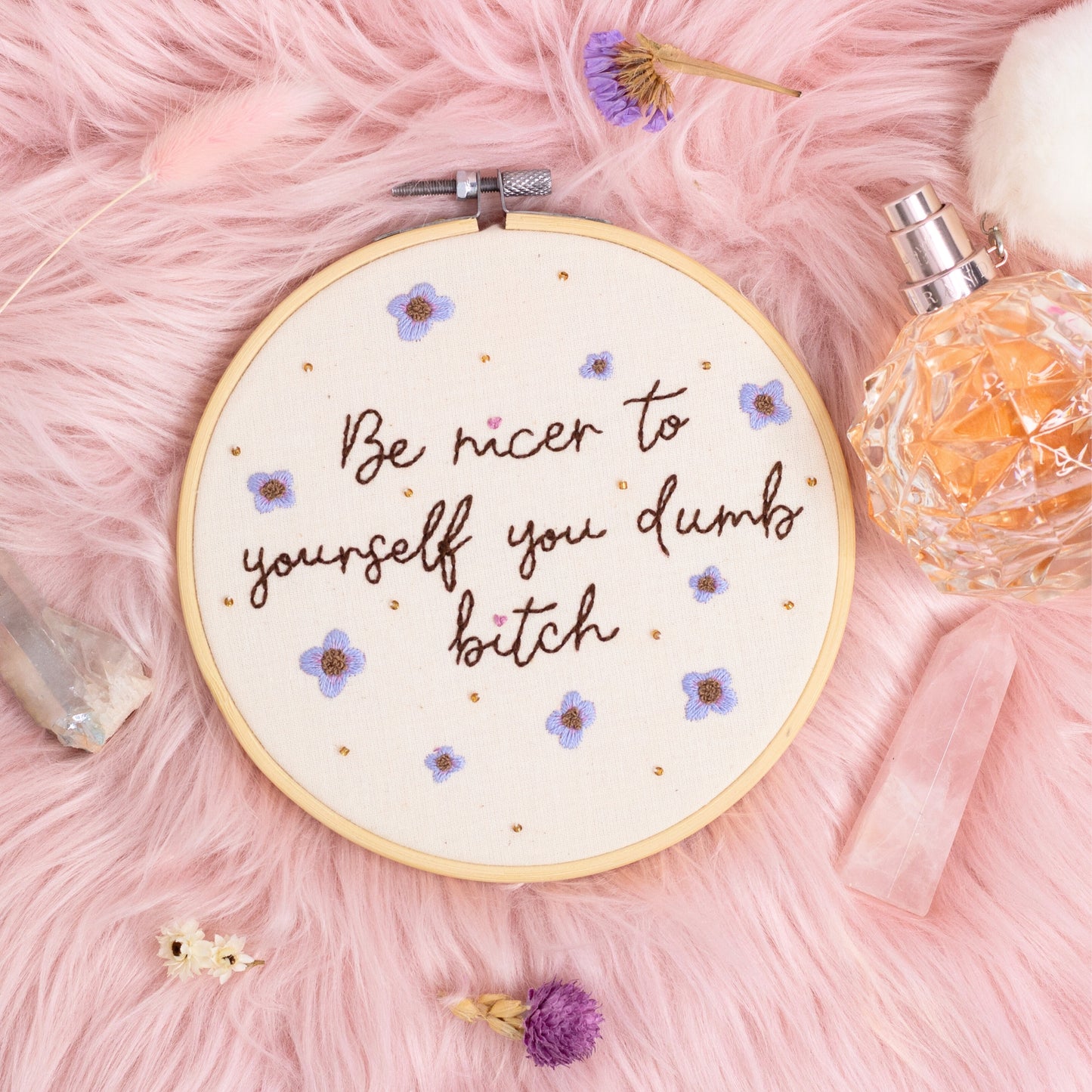 Hand embroidered quote hoop reading be nicer to yourself you dumb bitch styled on pink faux fur with crystals and perfume bottle