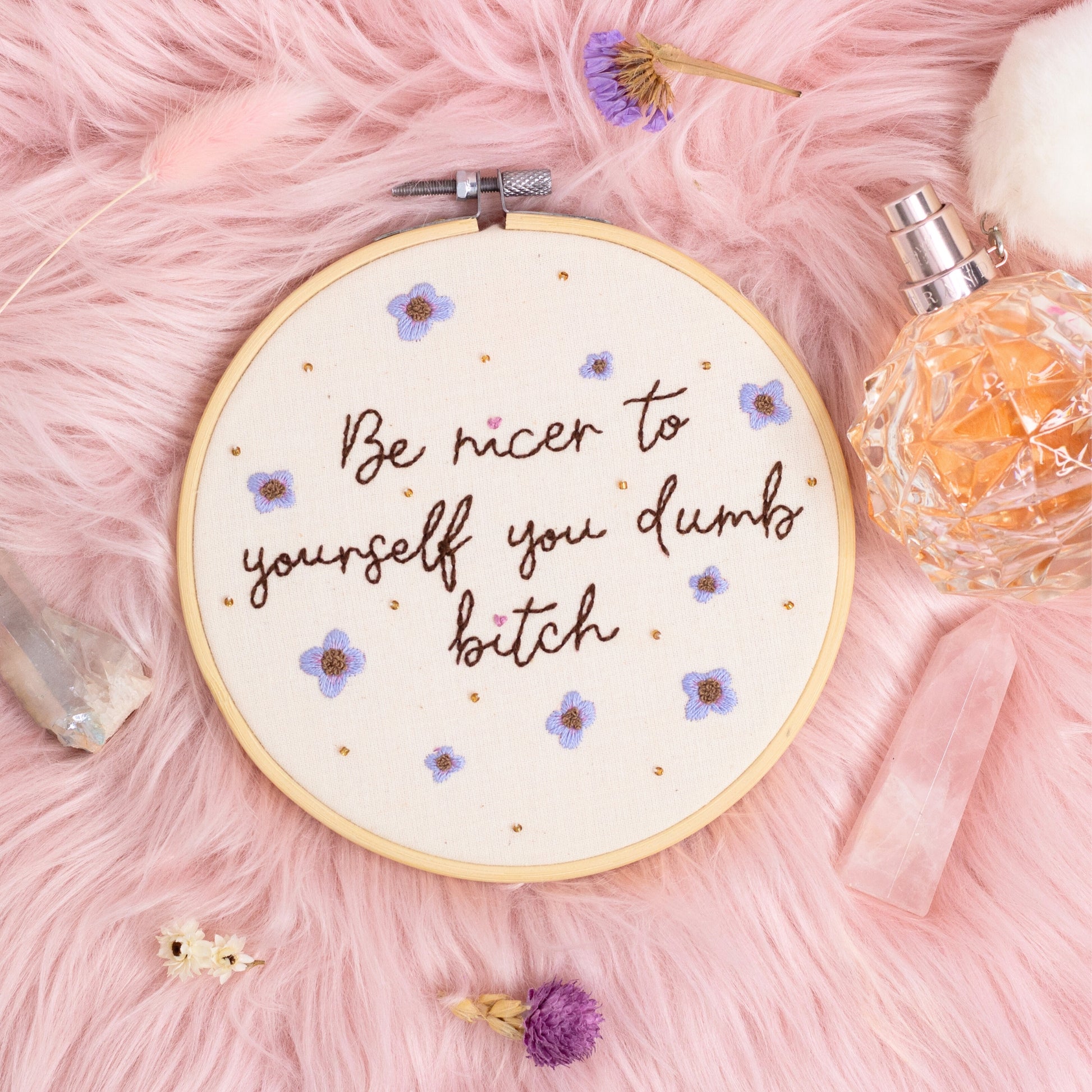 Hand embroidered quote hoop reading be nicer to yourself you dumb bitch styled on pink faux fur with crystals and perfume bottle