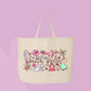 Large beige canvas tote bag featuring the words beach girlie surrounded by seashells, hibiscus flowers, palm trees, sea creatures, watermelon, and coastal doodles.