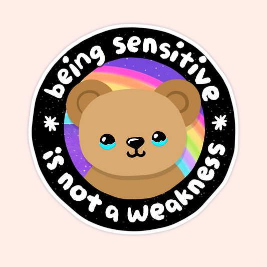 Round vinyl sticker featuring a teddy bear with a rainbow background and the phrase “Being Sensitive Is Not a Weakness.”