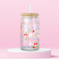Clear glass can tumbler with a soft pink background, covered in cherries, strawberries, lemons, flowers, bows, and pastel doodles for a sweet garden-inspired look.