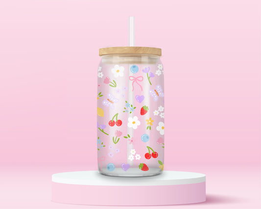 Clear glass can tumbler with a soft pink background, covered in cherries, strawberries, lemons, flowers, bows, and pastel doodles for a sweet garden-inspired look.