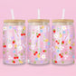 Clear glass can tumbler with a soft pink background, covered in cherries, strawberries, lemons, flowers, bows, and pastel doodles for a sweet garden-inspired look.