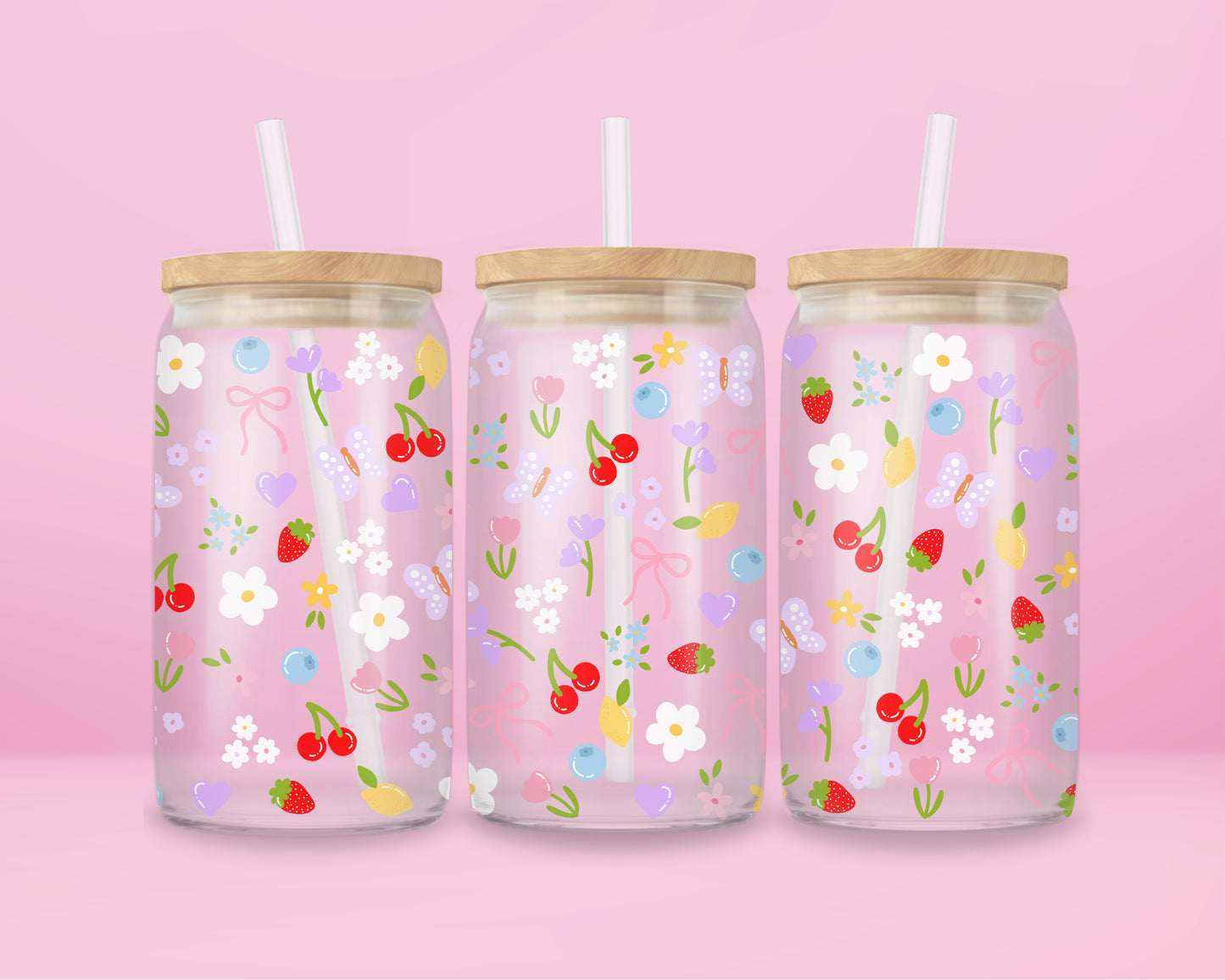 Clear glass can tumbler with a soft pink background, covered in cherries, strawberries, lemons, flowers, bows, and pastel doodles for a sweet garden-inspired look.