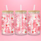 A sweet and soft glass cup covered in bunnies holding strawberries, red bows, white daisies, and hearts. Bunnycore perfection.