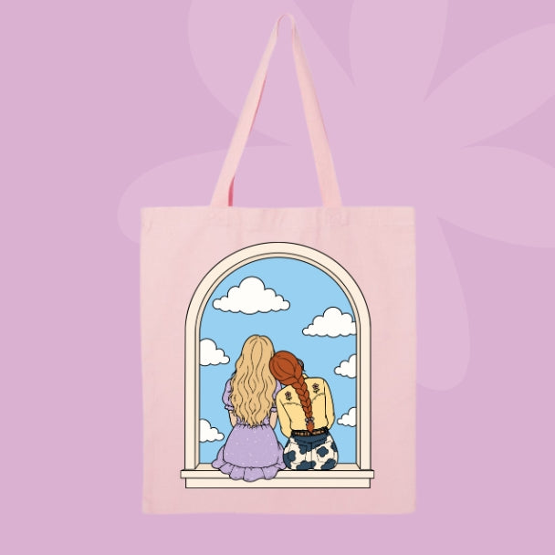 Pink canvas tote bag featuring two girls sitting together in an arched window with clouds and a blue sky.