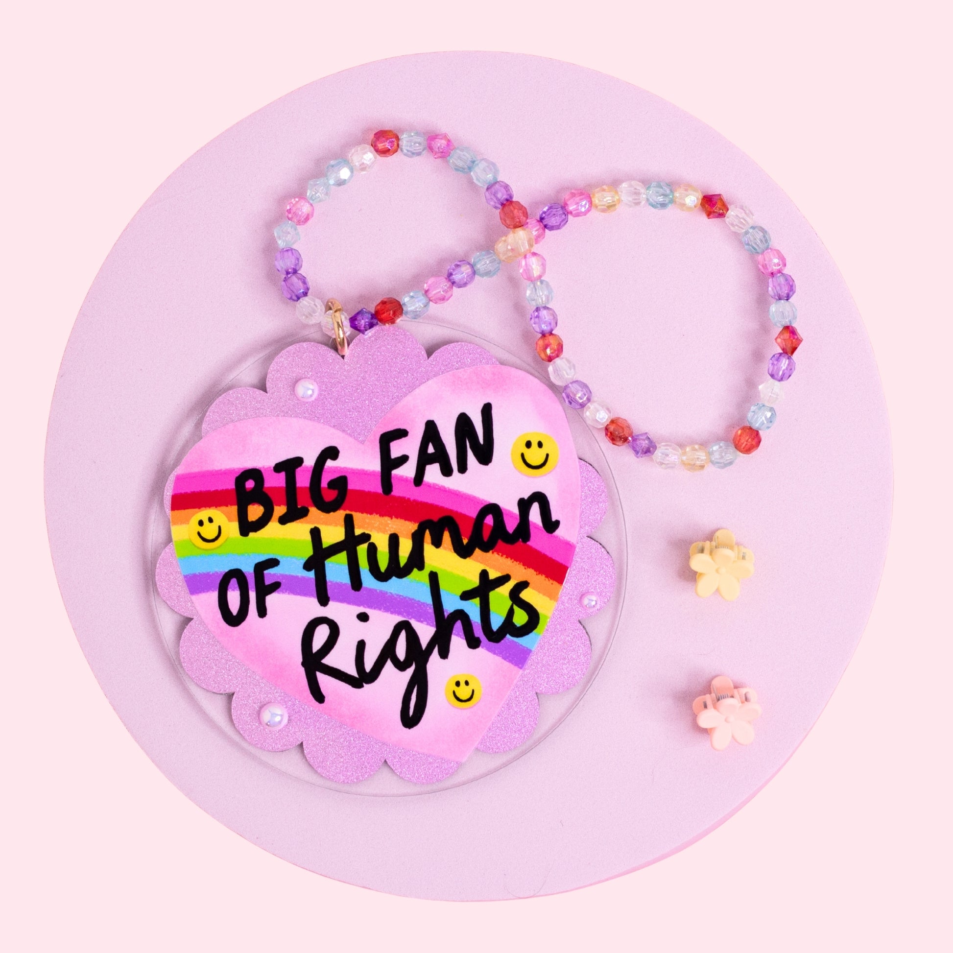 rainbow heart acrylic car charm with pink glitter background and colorful beaded hanger