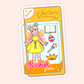 A whimsical vinyl sticker featuring a Bookish Girlie fantasy doll with magical accessories. Perfect for fantasy readers, book lovers, and cozy escapist vibes.