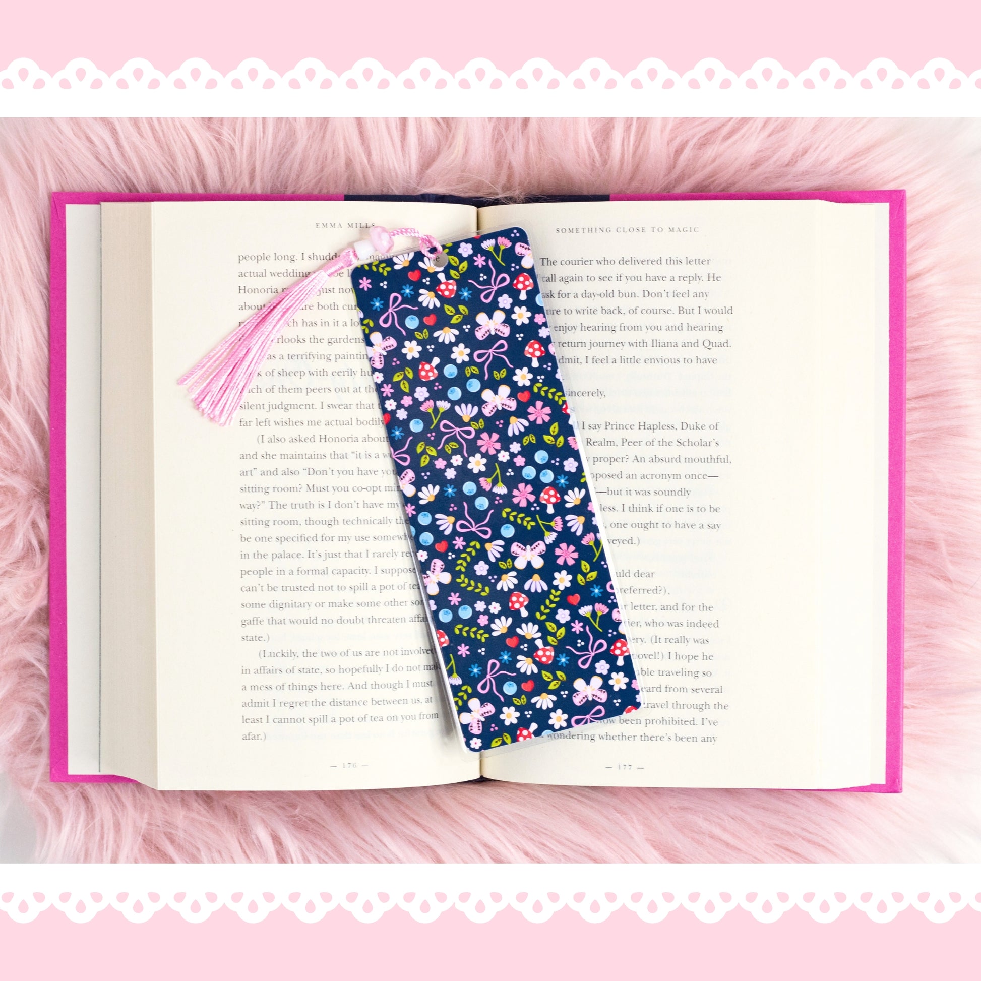 cute blue floral bookmark with bows and pink tassel on open book aesthetic pink background