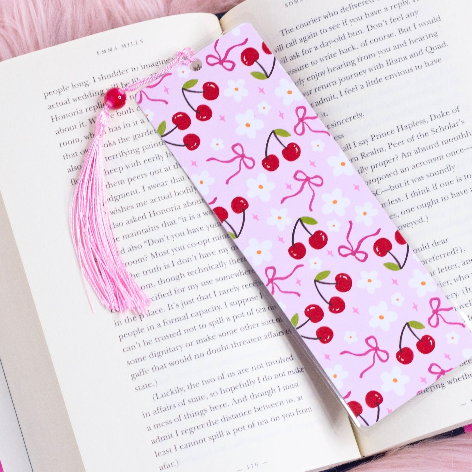 pink cherry bookmark with bows and flowers styled inside an open book
