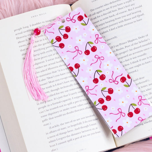 pink cherry bookmark with bows and flowers styled inside an open book