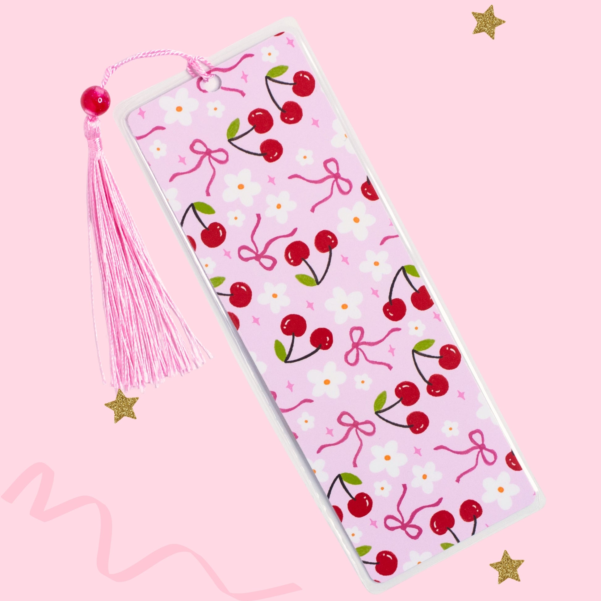 cherry bow bookmark with pink tassel on soft pink background