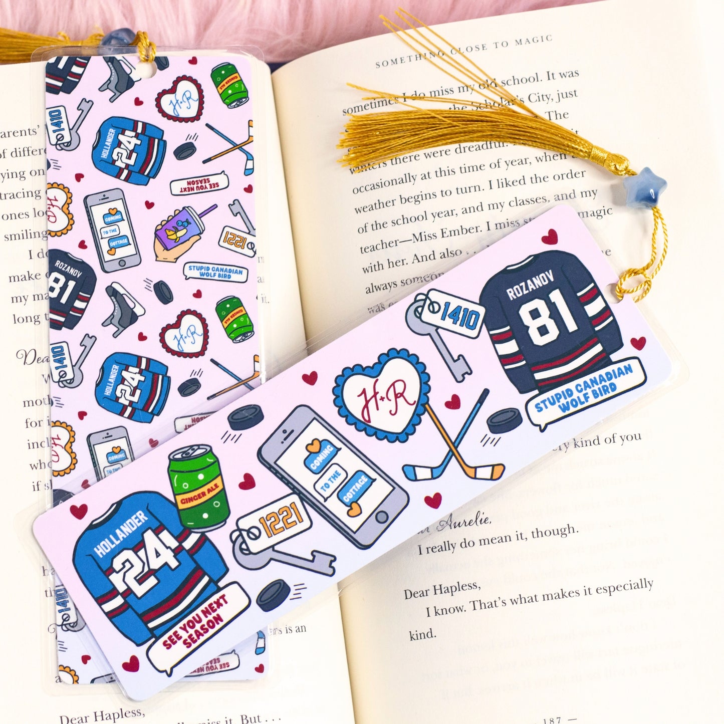 hockey romance bookmark inspired by heated rivalry with illustrated jerseys sticks and love details inside open book