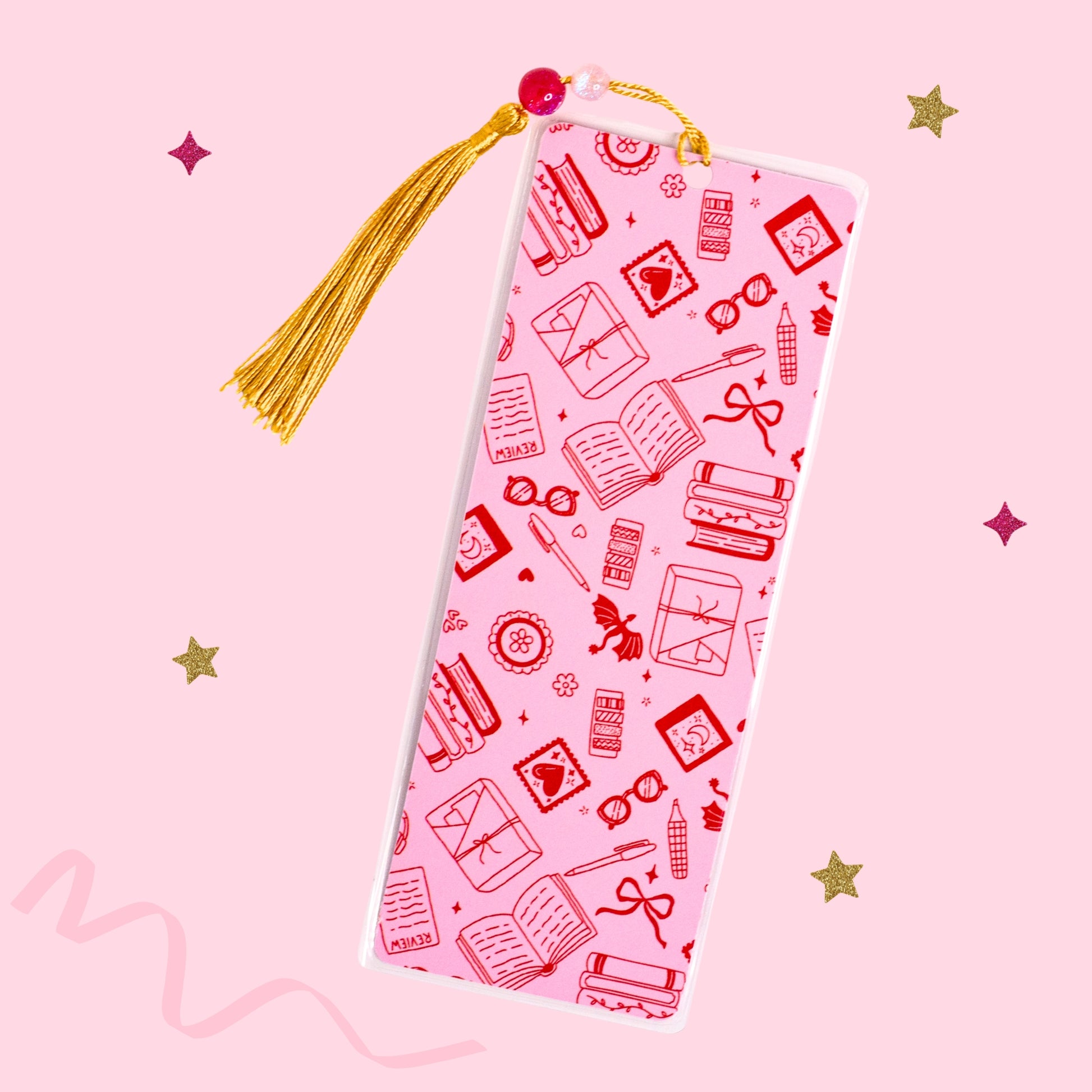 pink trope bookmark with red book lover illustrations and gold tassel on soft pink background