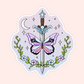 A mystical sword with butterfly wings in pastel colors, surrounded by vines, flowers, stars, and a crescent moon.
