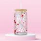 Pink glass can tumbler with cowgirl boots, bows, cherries, strawberries, and horseshoes in a coquette western pattern.