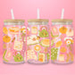glass tumbler decorated with pumpkins, bread, fall leaves, books, tote bags, and tea, with bamboo lid and straw.