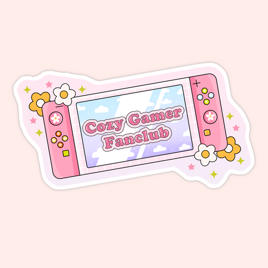Cute pink handheld gaming console illustrated with flowers and sparkles and the phrase “Cozy Gamer Fanclub” on the screen.