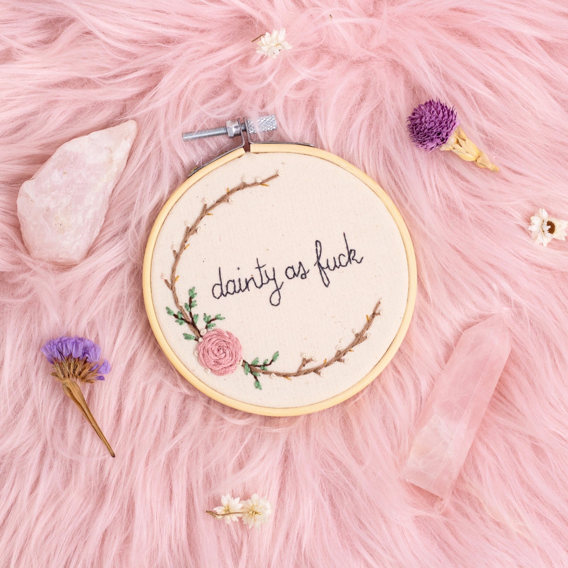 close up of dainty as fuck embroidered quote with floral embroidery in wooden hoop