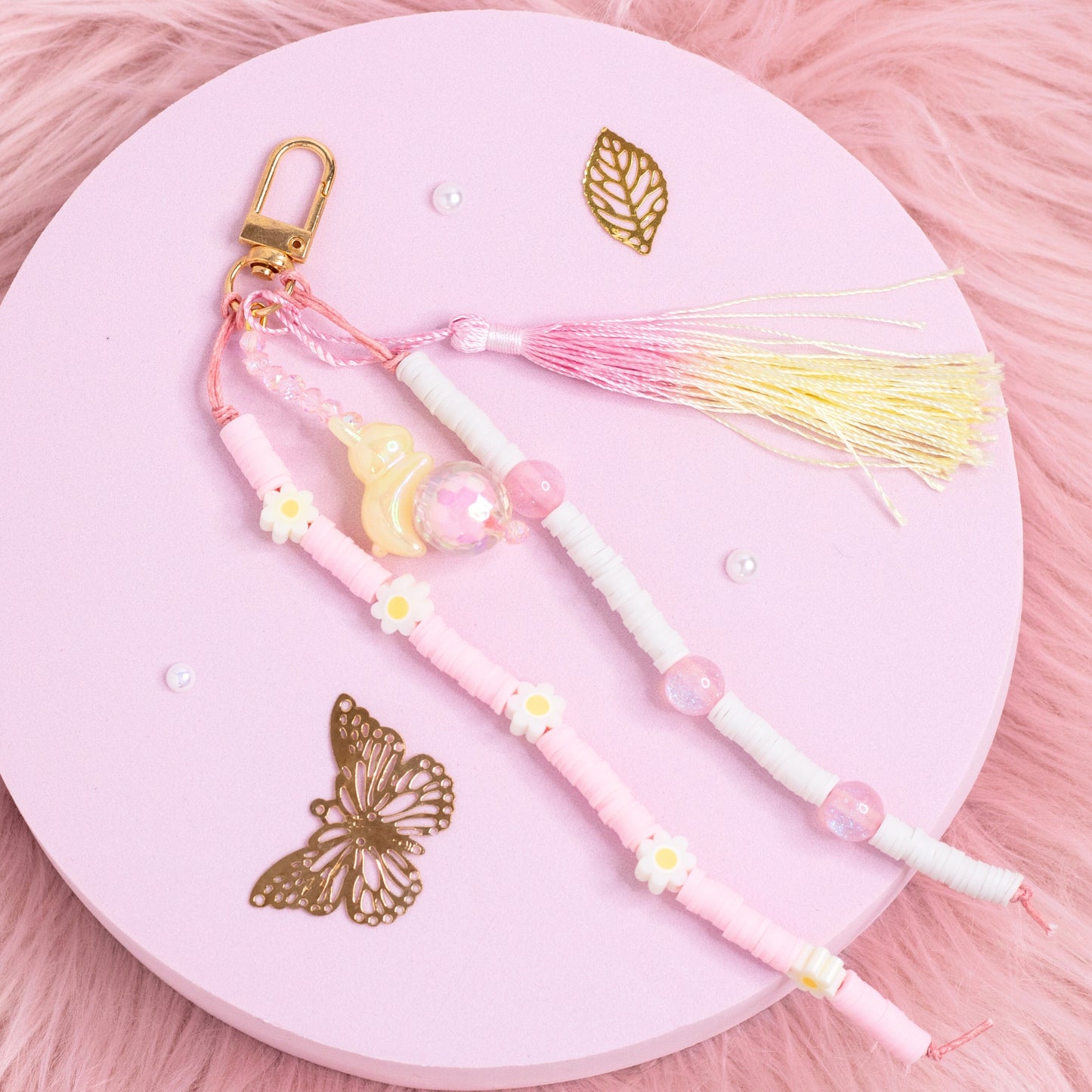 Daisy bunny beaded purse charm keychain with pastel beads, gold clasp, and pink tassel displayed on pink background