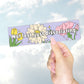 A hand holding a pastel purple bumper sticker that reads "Not lost, just dissociating" with illustrated flowers and sparkles.