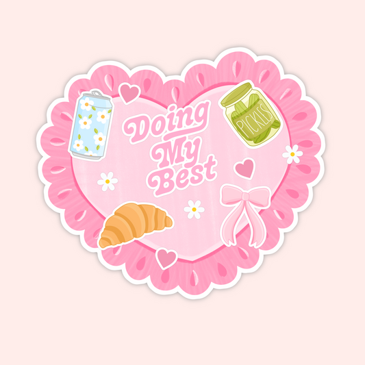 Pink scalloped heart sticker with daisies, bow, croissant, soda can and pickles that reads “Doing My Best.”