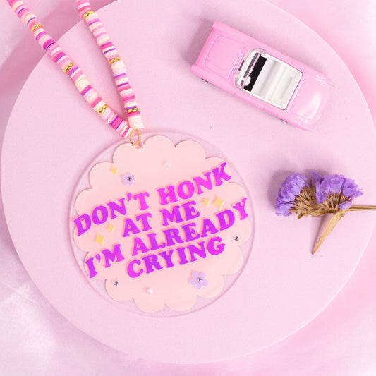 “Pink ‘Don’t honk at me I’m already crying’ car charm – soft, emotional, and very on-brand for sensitive girlies.”