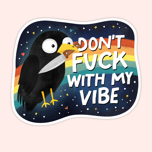 Black crow holding a knife in its beak in front of a rainbow night sky with the phrase “Don’t fuck with my vibe.”