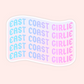 A die-cut sticker with a wavy flag-like shape featuring the phrase 'EAST COAST GIRLIE' repeated five times in a pastel gradient. The text transitions from light blue to lavender to pink, and the sticker has a white border on a pale pink background.