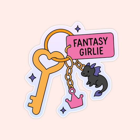 Whimsical sticker of a fantasy-themed keychain with a heart key, “Fantasy Girlie” tag, a mini dragon charm, and a pink crown charm.