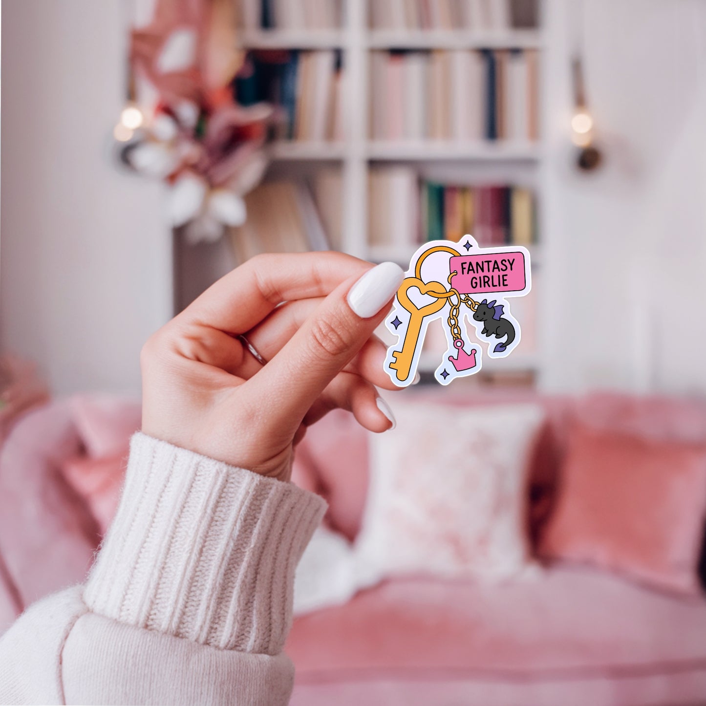 Whimsical sticker of a fantasy-themed keychain with a heart key, “Fantasy Girlie” tag, a mini dragon charm, and a pink crown charm.