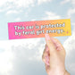 A hand holding a gradient pink-to-yellow bumper sticker with the text "This car is protected by feral girl energy" and sparkles.