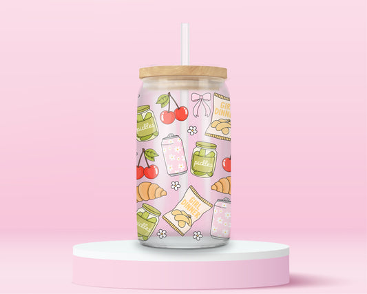 glass tumbler with jars of pickles, cherries, croissants, bows, and “Girl Dinner” snack bags, with bamboo lid and straw.