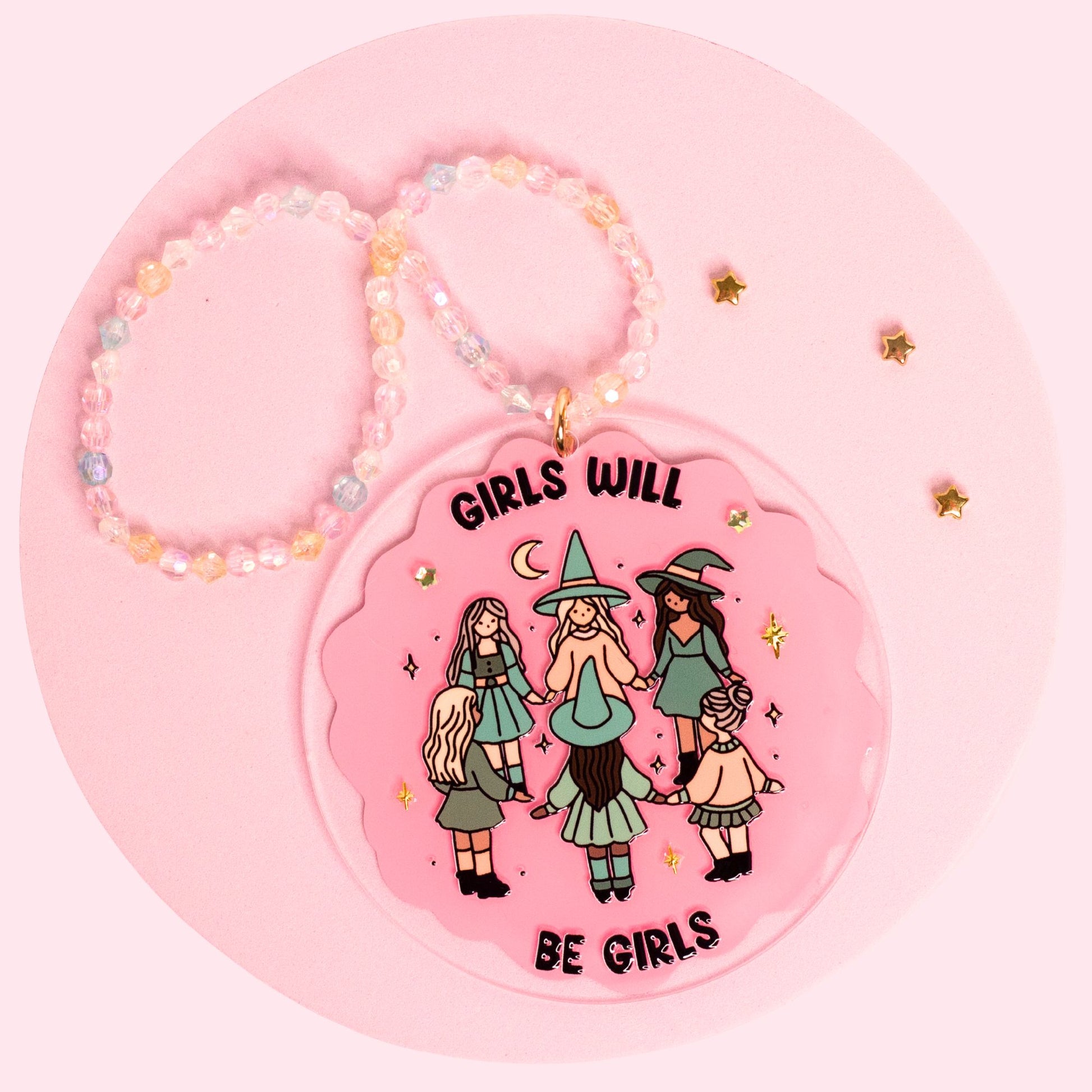 Girls Will Be Girls car charm featuring a pink witchy girl gang design with gold stars, sparkly details, and a pastel beaded hanger.