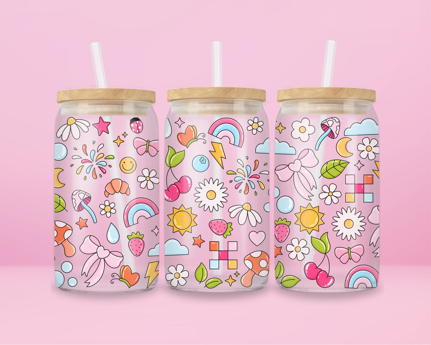 Glass can tumbler with bamboo lid and glass straw featuring colourful doodles including bows, rainbows, mushrooms, daisies, stars, hearts, bubbles, and butterflies on a pink background.